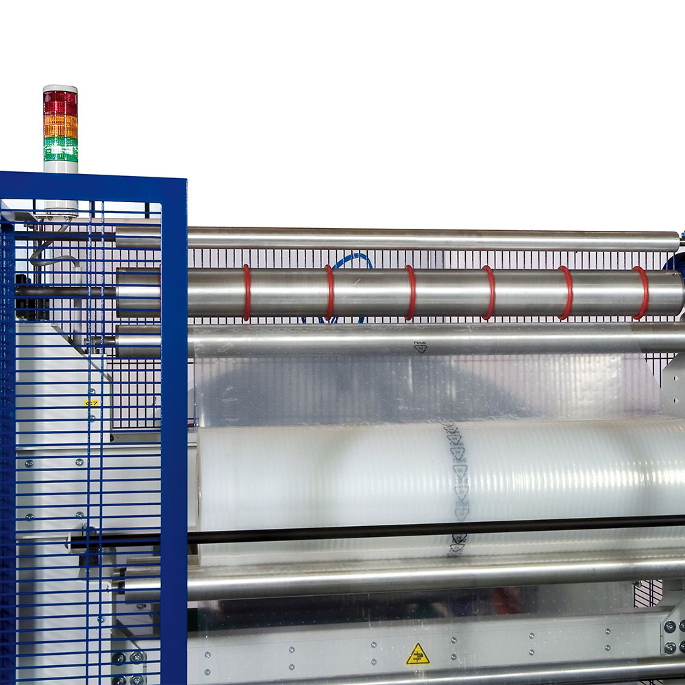 Internal view of TC ST Total Close horizontal wrapper showing polyethylene film spools and roller system for precision industrial packaging automation